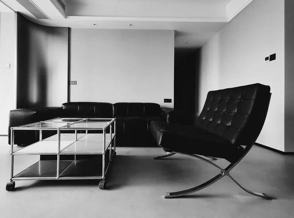 Barcelona Chair im Profil in einem modernen Wohnzimmer, die gekreuzten Stahlbänder laufen frei unter der Sitzfläche durch