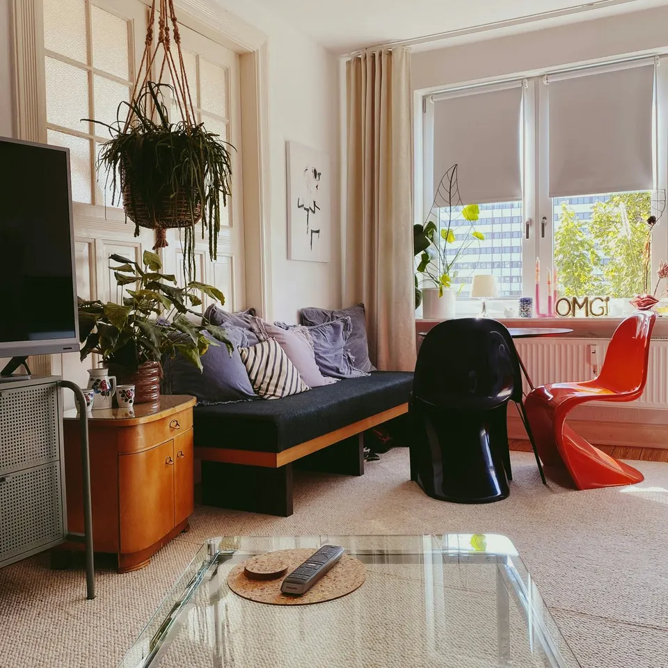 Zwei Panton Chairs in Schwarz und Rot im Profil, die geschwungene Kufe läuft ohne Hinterbein bis auf den Boden