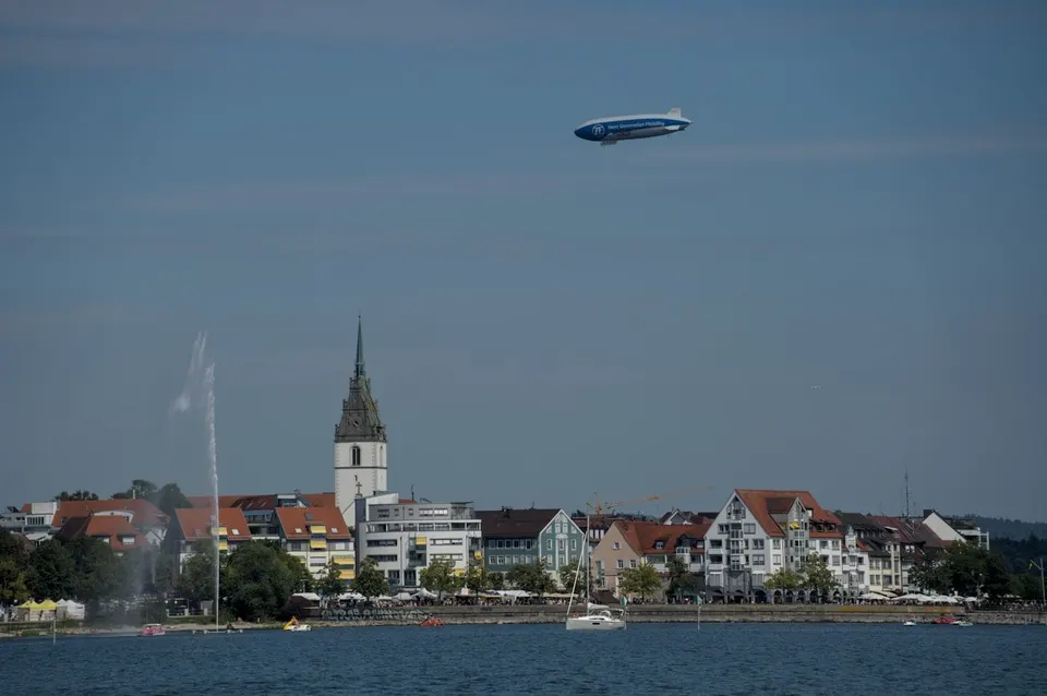 Zeppelin NT am Himmel ueber der Uferpromenade von Friedrichshafen am Bodensee